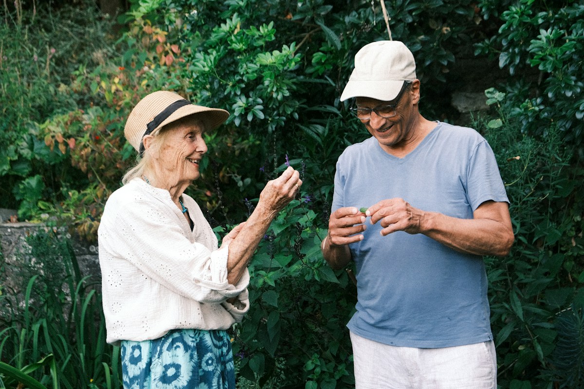 Personas mayores observando plantas en un jardín; fotografía ilustrativa
